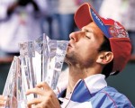 El serbio besa el trofeo que le acaba de ganar a Rafael Nadal.