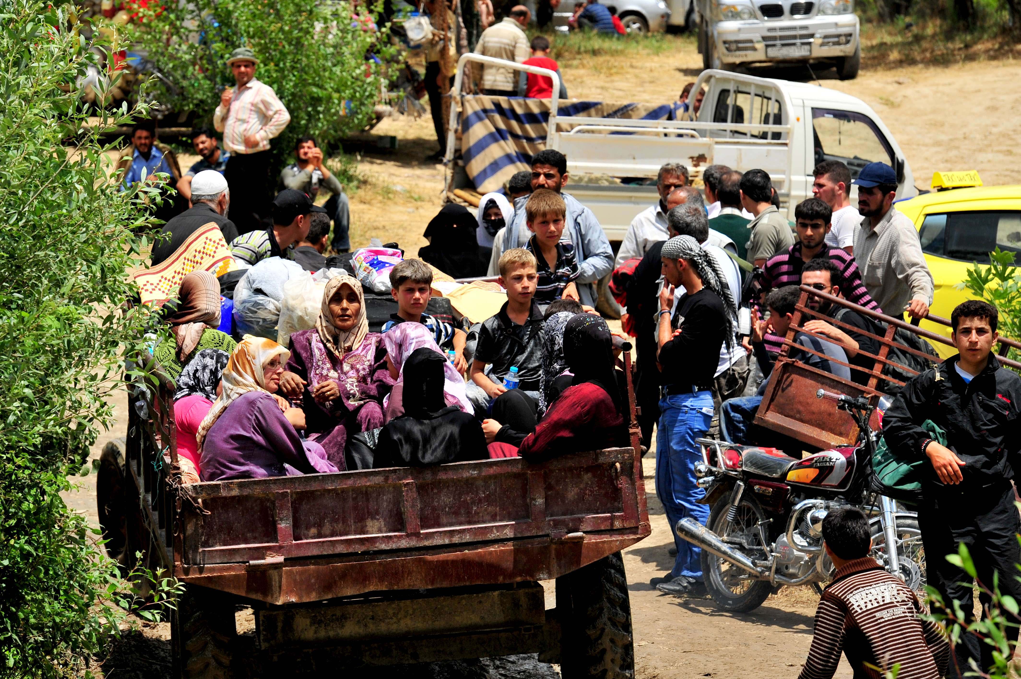 Syrian internally displaced persons arrive to a makeshift camp in the northern city of Idlib, near the Turkish village of Guvecci in Hatay, on June 13, 2011. More than 10,000 Syrians have fled into neighboring countries to escape a deadly government crackdown on opposition protests, the UN said today, with at least 5,000 people escaping to Turkey and at least 5,000 escaping to Lebanon. AFP PHOTO / MUSTAFA OZER